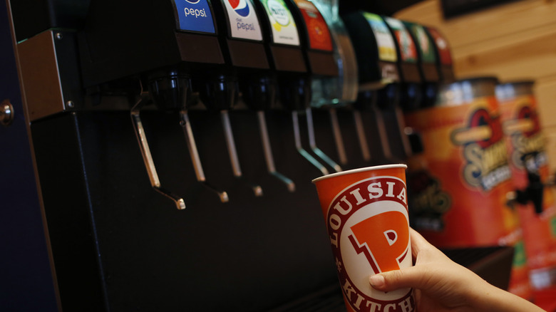 Customer filling up cup with soda