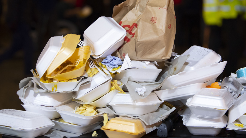 Discarded food containers cluttering a trash can