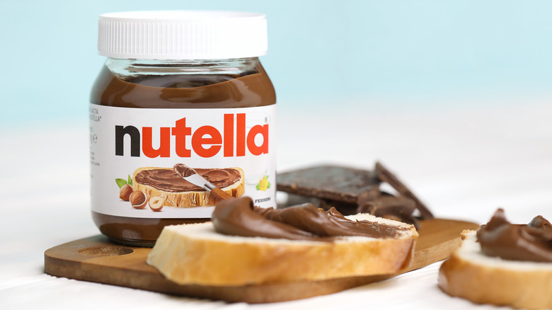 Jar of Nutella with bread covered in Nutella