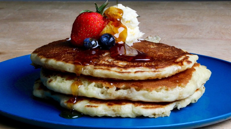 Stack of pancakes with fruit and syrup