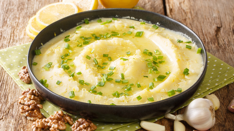 Mashed potatoes topped with chives in black bowl