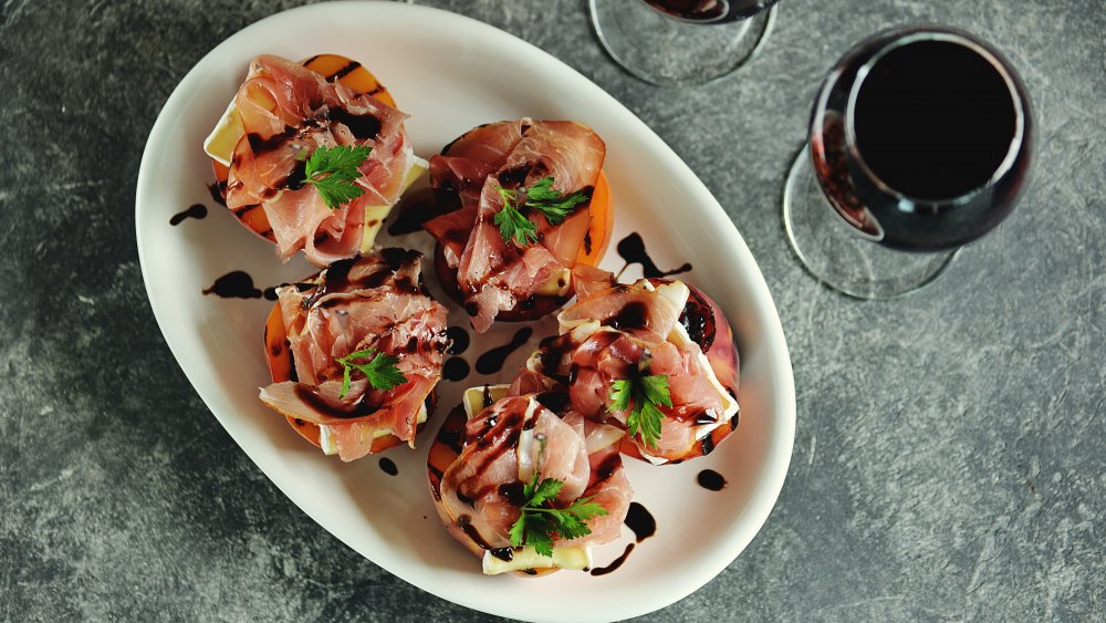 Grilled peaches topped with cheese, prosciutto, and balsamic glaze