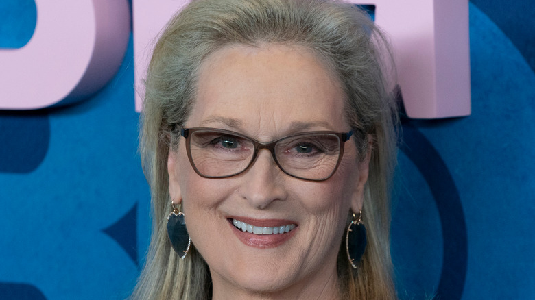 Meryl Streep smiles with glasses and heart earrings