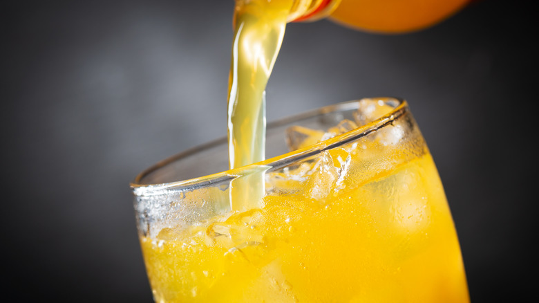 orange soda being poured into glass