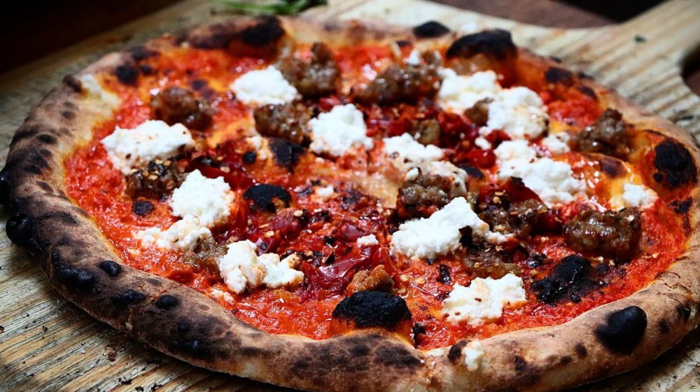Wood-fired pizza with sausage and goat cheese.