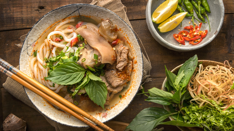 Bowl of bún bò Huế with chopsticks on a wooden table