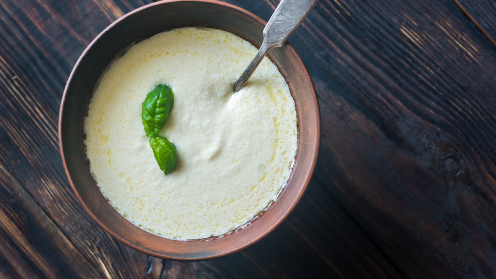 A bowl filled with Alfredo sauce