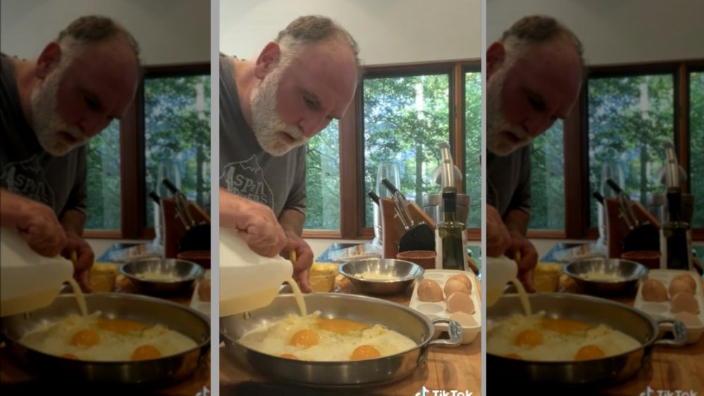 Jose Andres making eggs, pouring milk into pan.