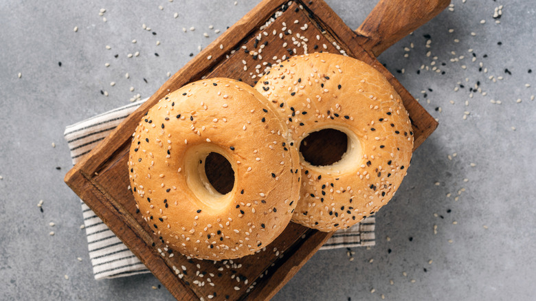 Two bagels on a wooden cutting board