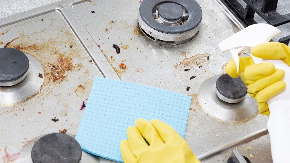 Hands cleaning the stove top