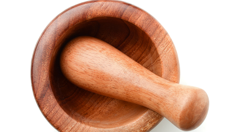 A wooden mortar and pestle on a white background