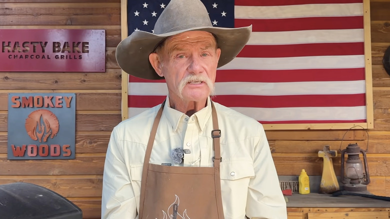 Cowboy Kent Rollins in a cowboy hat and apron.
