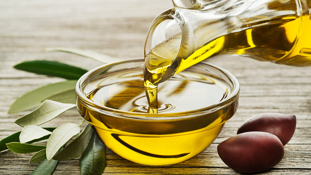 Pouring olive oil into a glass bowl