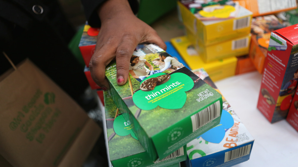 Hand grabbing Girl Scout cookie box