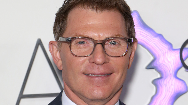 Bobby Flay wearing a suit and smiling