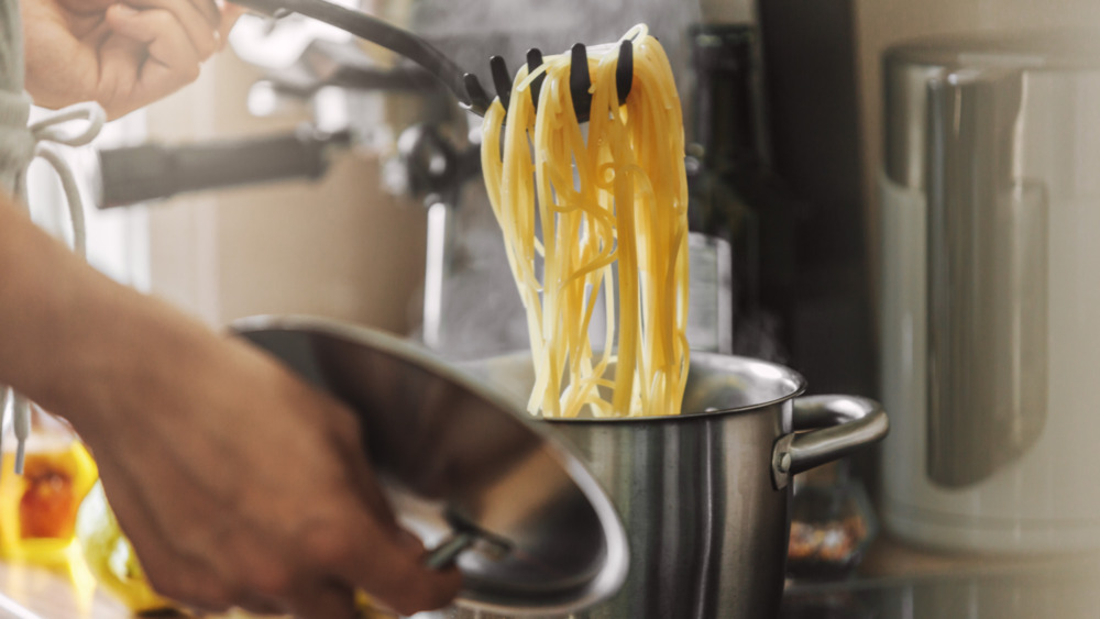 Person boiling pasta in a chrome pot