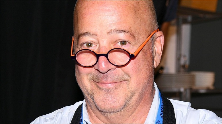 andrew zimmern smiling with glasses