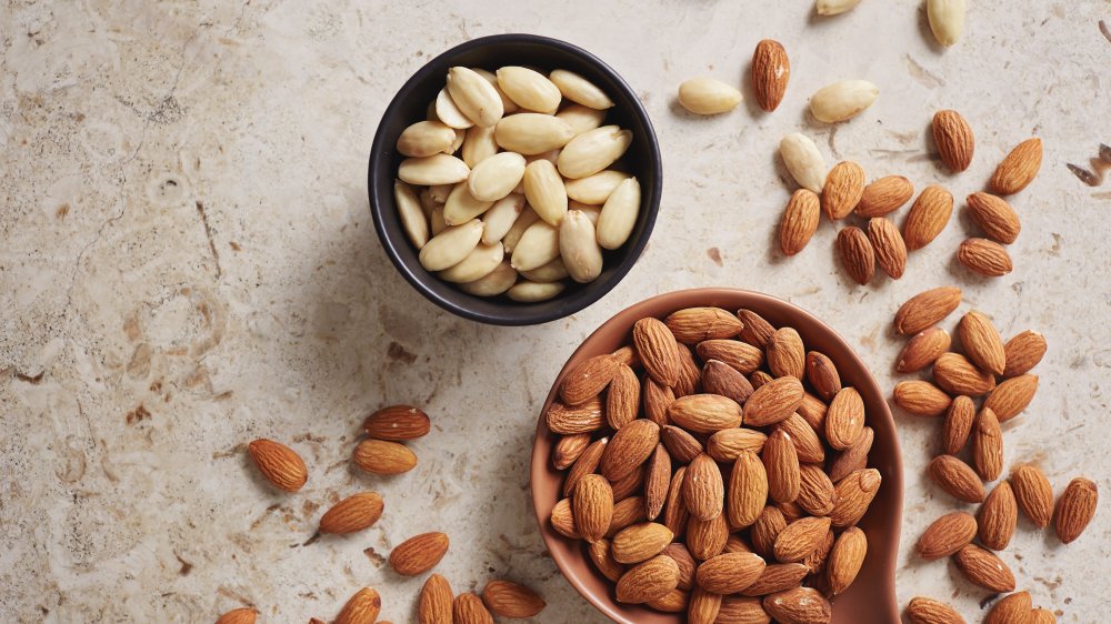 spoon with almonds and bowl of blanched almonds