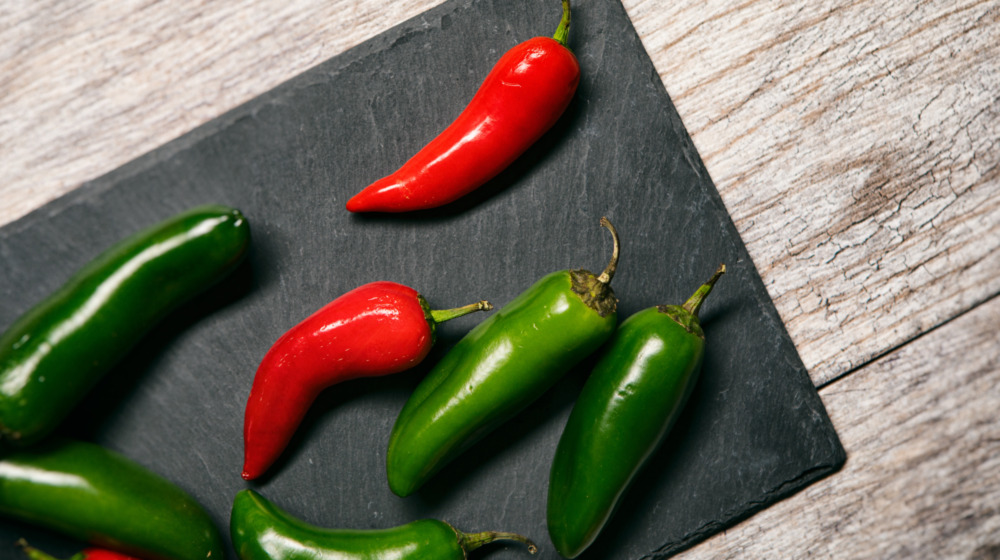 Red and green jalapeños on board
