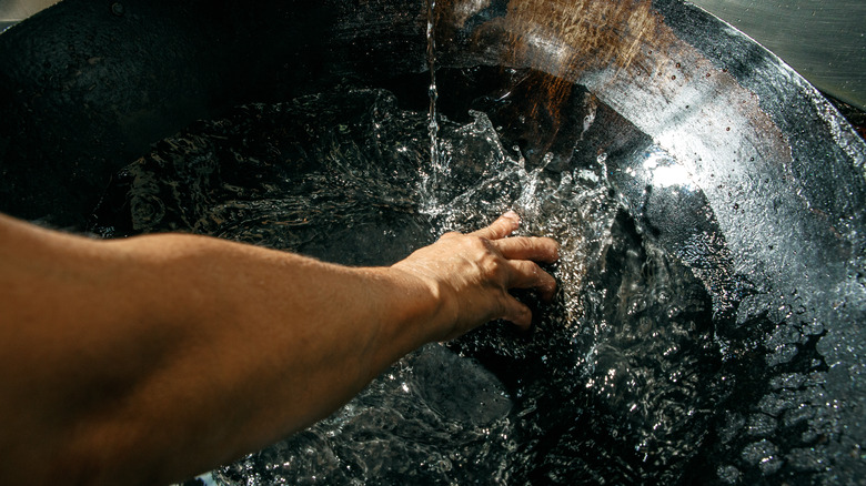 Rinsing a kitchen wok with water