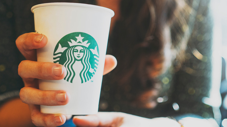 Customer holding a Starbucks cup