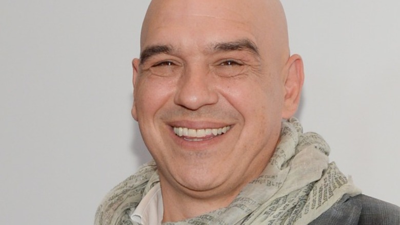 Michael Symon smiling, wearing scarf