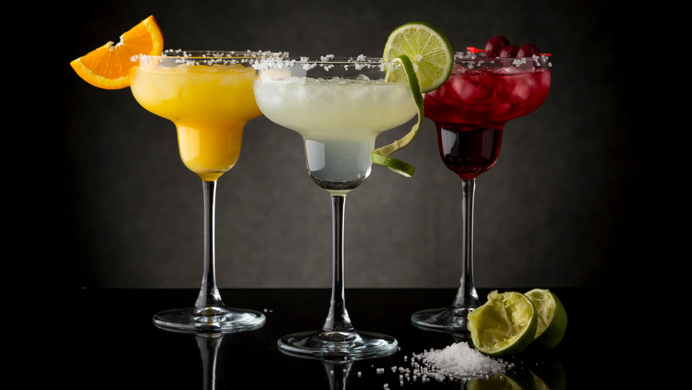 three margaritas with salted rims, lime margarita, orange margarita and cranberry margarita 