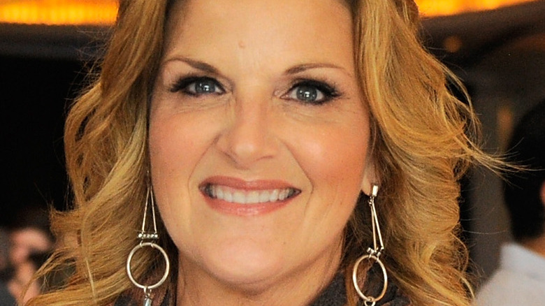 Trisha Yearwood smiles with dangling earrings