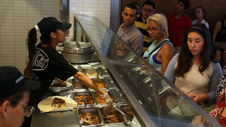 customers and employees in Chipotle assembly line