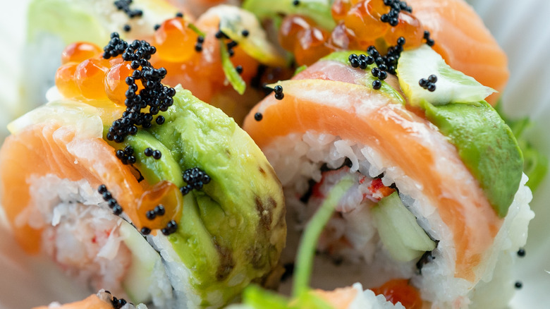 A close-up of sushi with salmon and black caviar