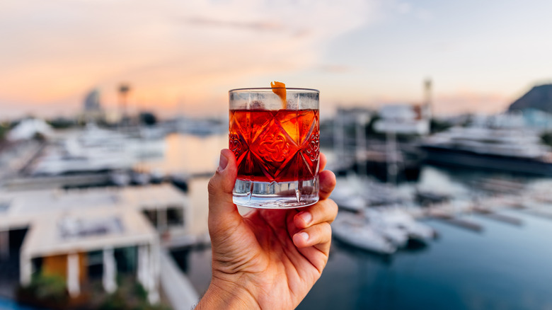 hand holding Negroni with orange twist