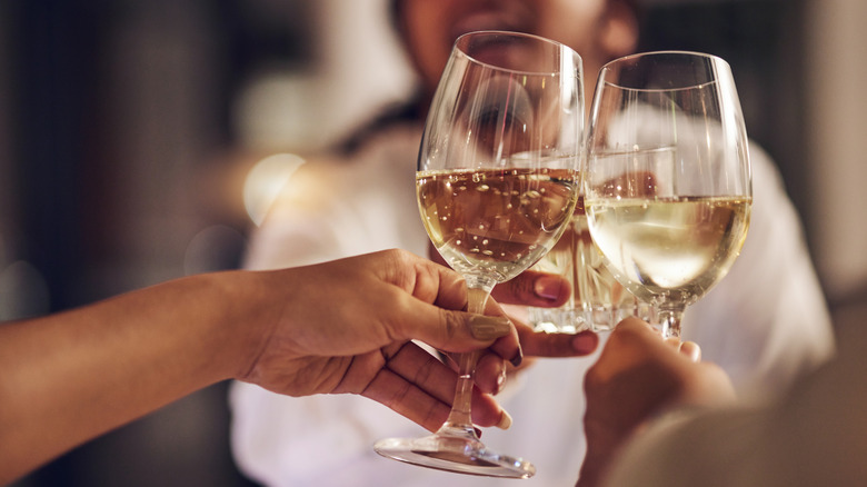 people raising Champagne glasses to toast