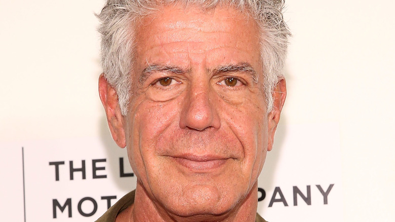 Anthony Bourdain smiling against white background