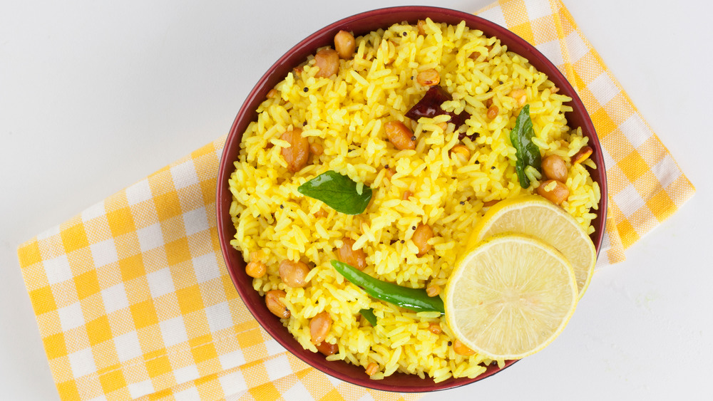 Bowl of yellow rice with lemon on napkin