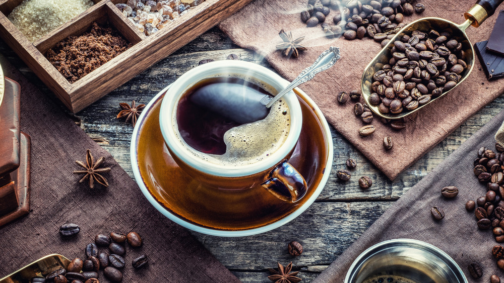 Hot cup of coffee with coffee beans