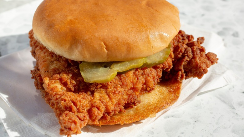 A close-up of a chicken sandwich with pickles