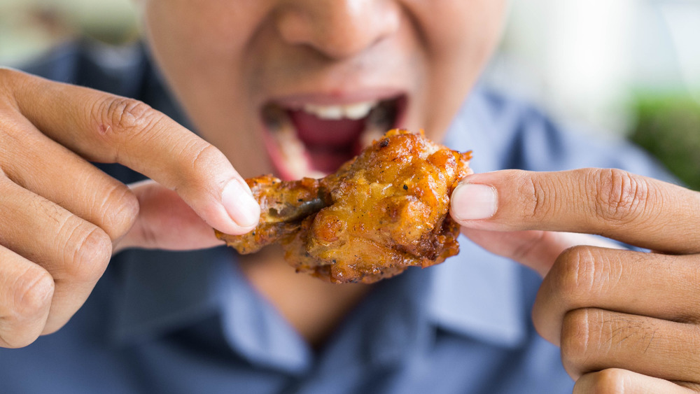 Person eating chicken wing