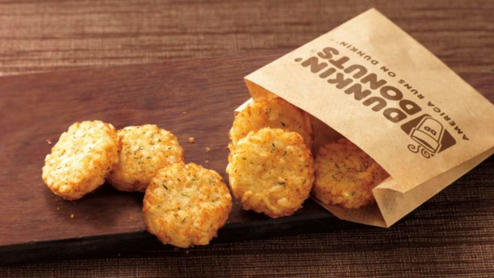 Dunkin' hash browns with paper sleeve and wooden board