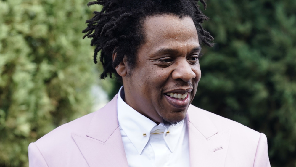 Jay-Z smiling while wearing a pink suit