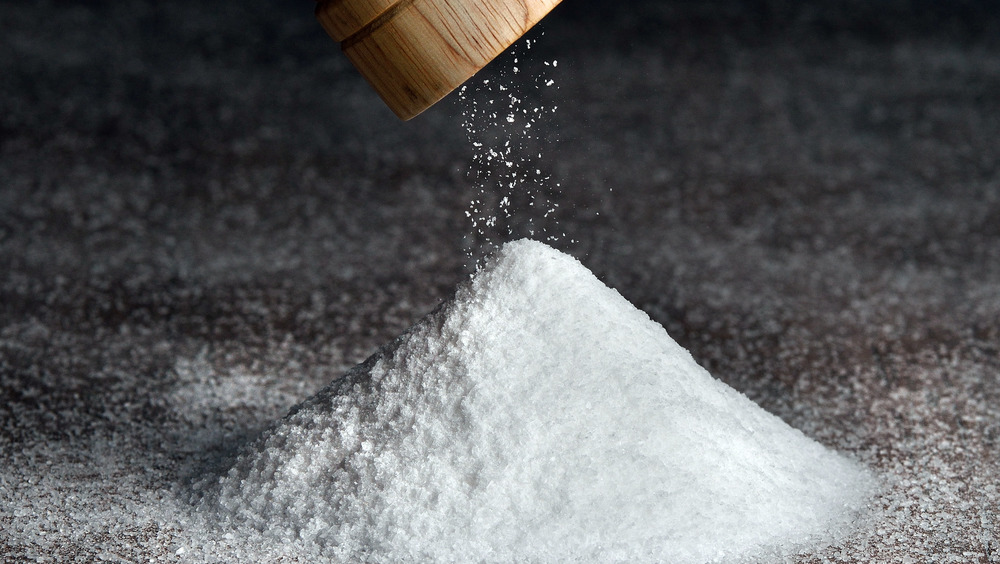 A grinder grinding salt into a pile