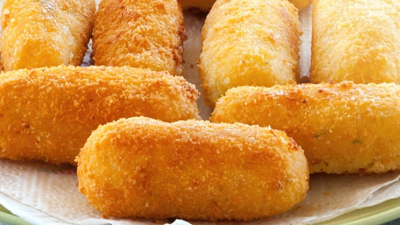 Potato croquettes on a paper towel-lined plate