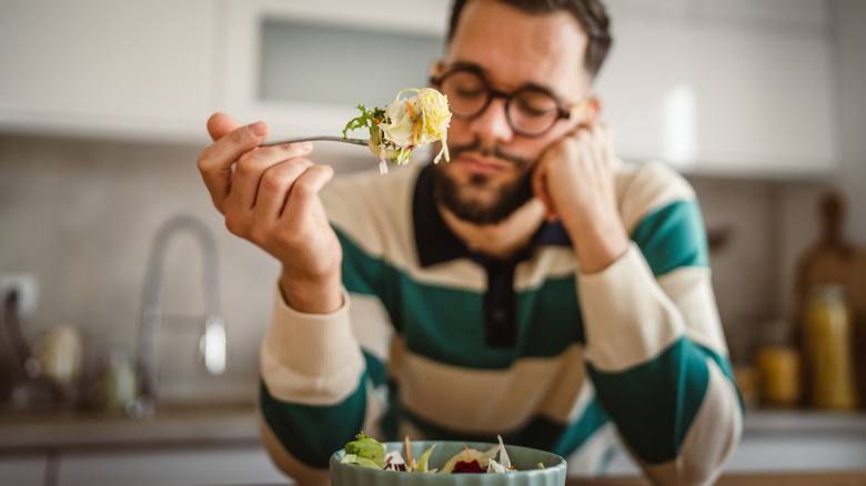unhappy man eating a salad