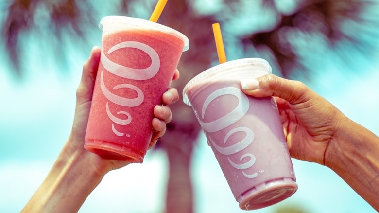 Two people hold up a Jamba smoothie