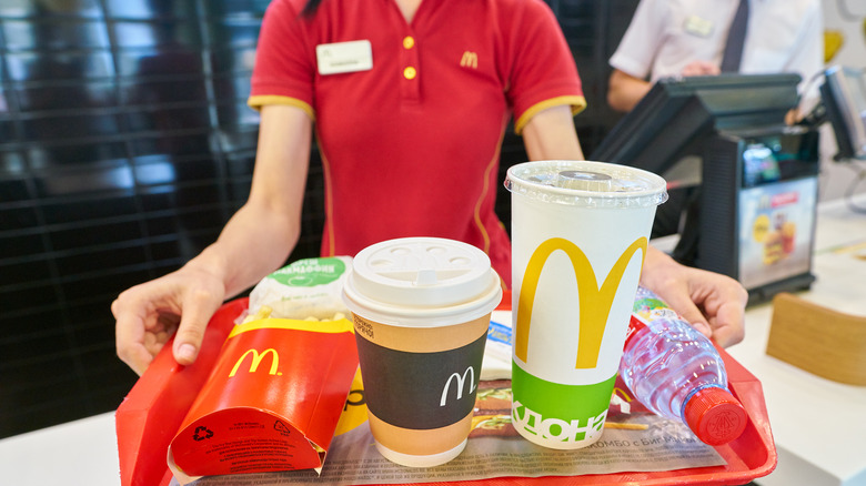 McDonalds worker holding tray of food