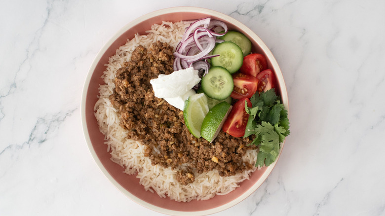 Ground beef keema rice bowl with veggie toppings and yogurt