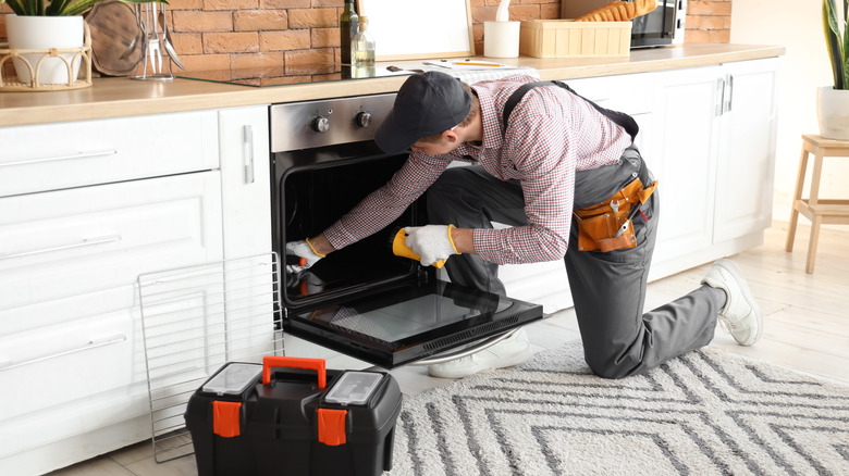 Worker repairing oven