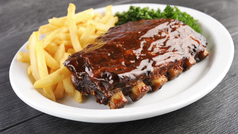 Barbecue ribs and fries on white plate