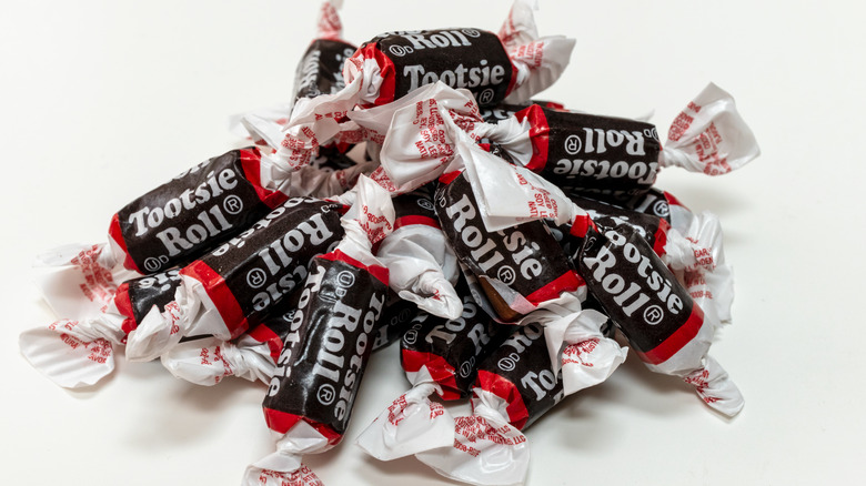A bunch of Tootsie Rolls on white background