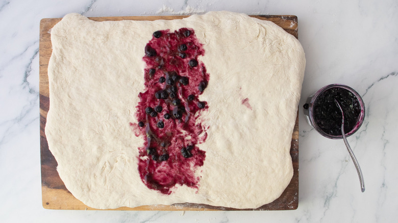 Dough rectangle with blueberry jam spread down the middle