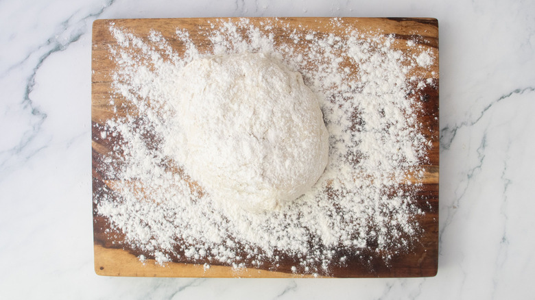 Bread dough sitting on floured work surface